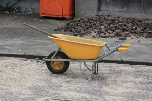 Yellow wheelbarrow, used for road renovation