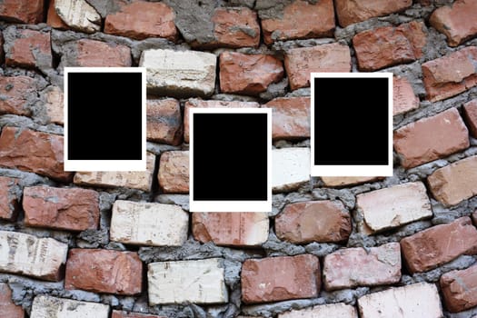 set of three old blank polaroids frames lying on a brick surface 