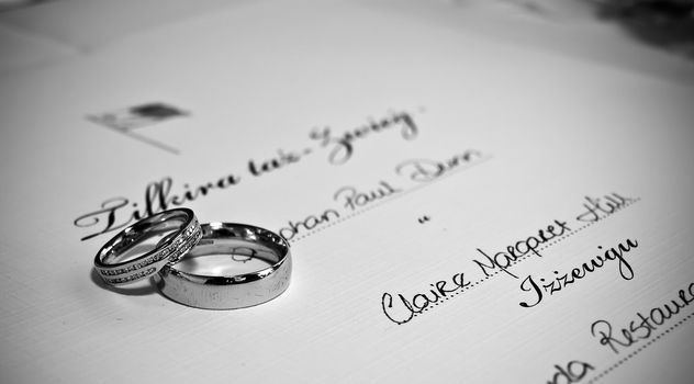 A pair of platinum wedding bands lying on Malta civil wedding certificate