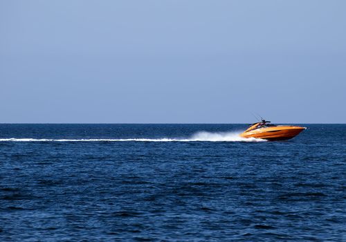 Orange speedboat speeding along the Mediterranean Sea off the coast in Malta