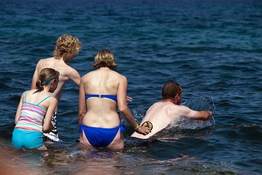 A family enjoys the crystal clear Mediterranean waters of Malta