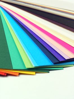 Colored samples of different papers on white background, business cards