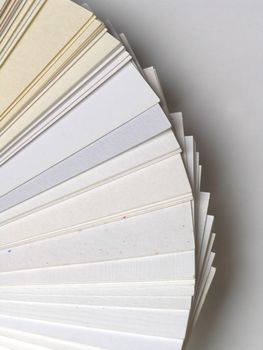 Colored samples of different papers on white background, business cards