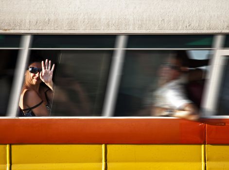 Woman waving out of the window of a Malta Bus
