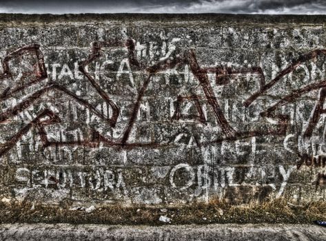 Graffiti and inscriptions on a limestone wall shot in HDR