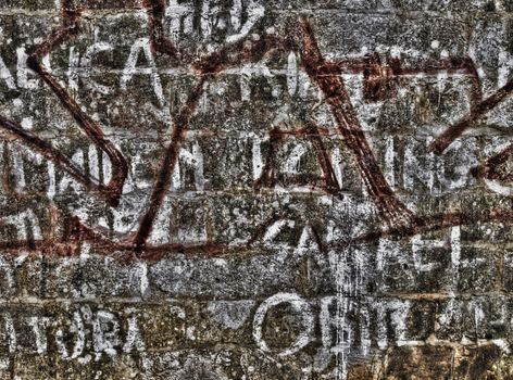 Graffiti and inscriptions on a limestone wall shot in HDR
