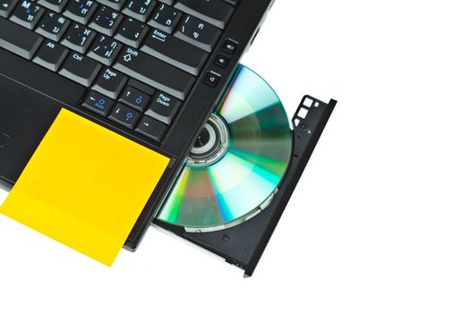 close up of a dvd in a laptop tray and post-it