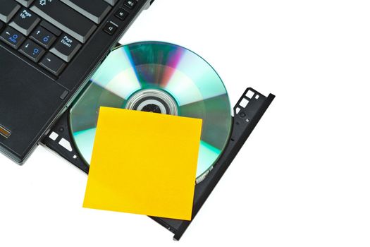 close up of a dvd in a laptop tray and post-it