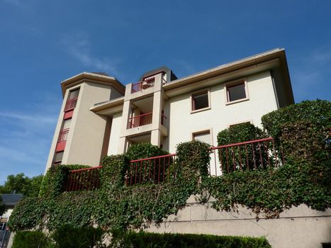 White modern house and vegetation in front of it by beautiful weather