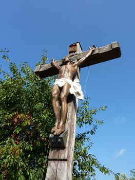 Jesus on a wood cross with blue sky