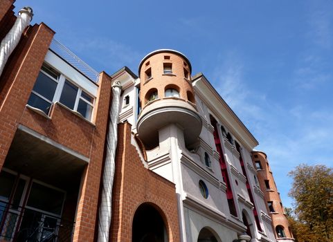 Eccentric orange and white facade of a building with a tower and small windows by beautiful weather