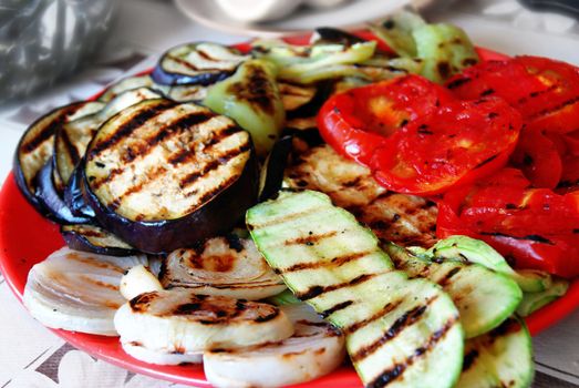 grilled paprika, tomatoes and aubergines served on red plate