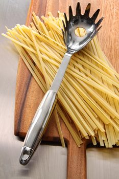 Raw fettuccine on wooden cutting board