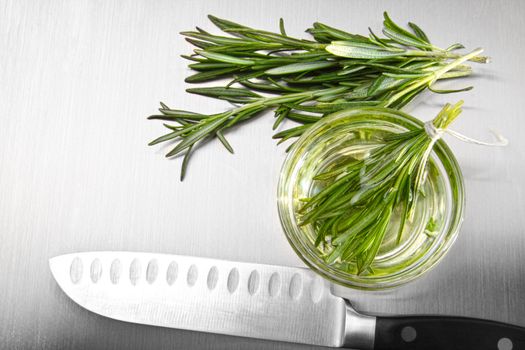 Sprigs of rosemary leaves with cutting on stainless steel counter