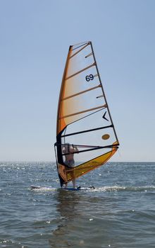 Windsurfer sailing among the waves
