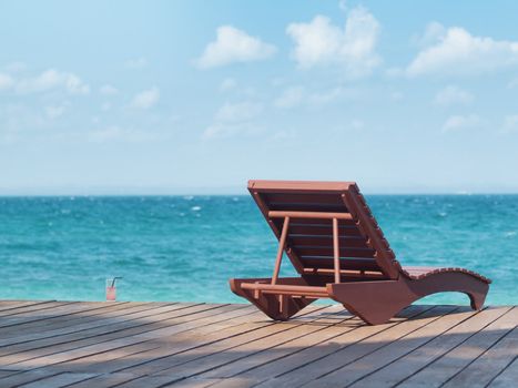 Empty beach chair with drink at a resort facing the south China sea in Pulau Besar Malaysia