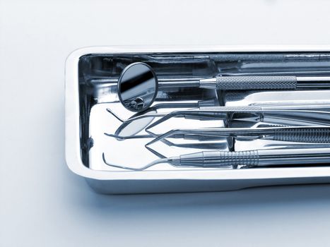 Close-up Dental Instruments on white background, metal, iron, steel, mirror, blue shadows