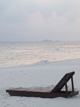 Empty  wooden chair on the beach at  dawn  on an tropical island