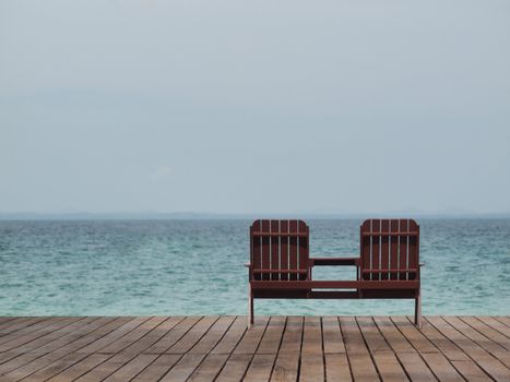 Two empty chair at a resort facing the south China sea in Pulau Besar Malaysia with a boat in the background