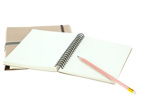Isolated Light cream color paper note book on brown book and pencil