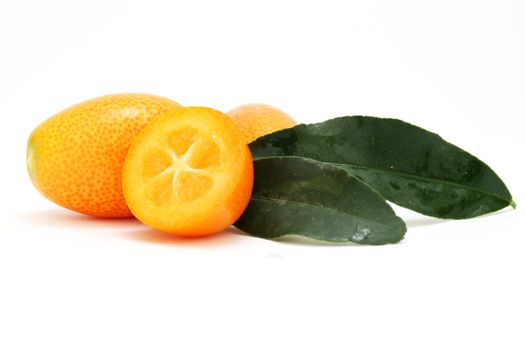 a few kumquats including a sliced one isolated on a white background