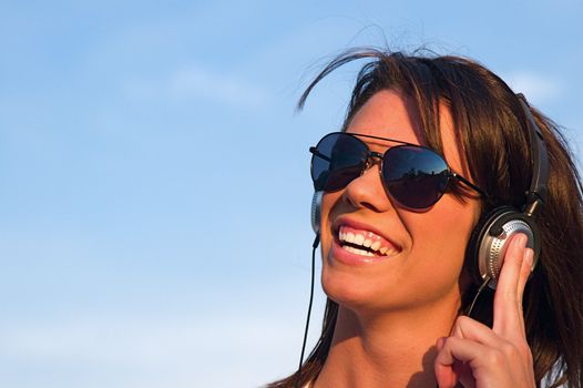 A cool young woman listens to music on some headphones