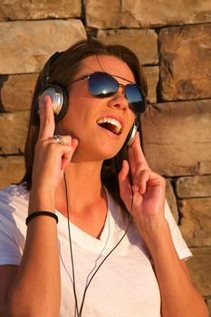 A cool young woman listens to music on some headphones