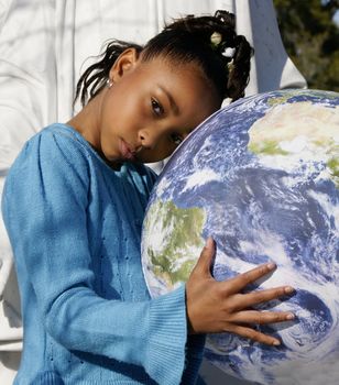 An African-American girl holding the NASA Earth Ball.