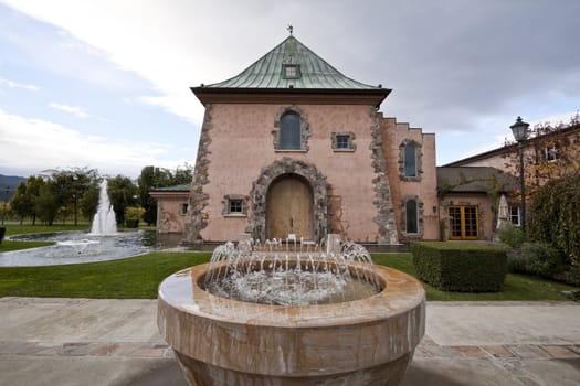 A bunch of fountains around the entrance of a building