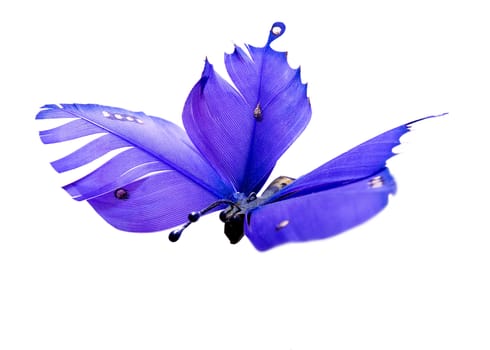 A decorative butterfly made out of painted feathers and wood.