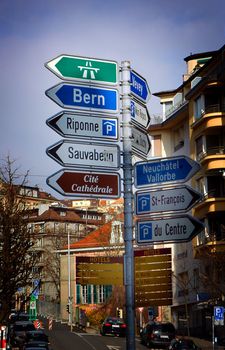 Various directional street signs on one post within Lausanne, Switzerland.