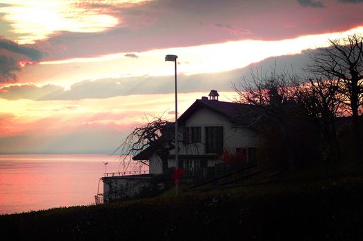 Sunset on lake Geneva behind a restaurant outside Lausanne, Switzerland.