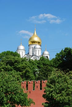 Red brick wall and white stone cathedral in Moscow Kremlin, Russia