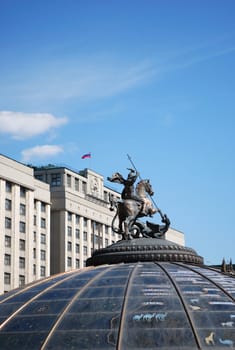 Building of State Duma of Russian Federation with flag and Emblem of Moscow - statue of St.George
