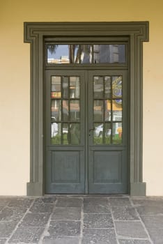 Front shot of a rustic brown wooden door, with cream coloured wall.