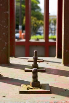 Detail in perspective of a line of three structural bolts.