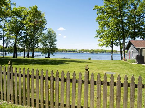 A picket fence, overlooking a body of water. Taken from a vacation spot.