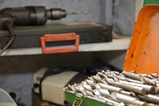 Detail shot of a boxset of drillbits with drill in the background.