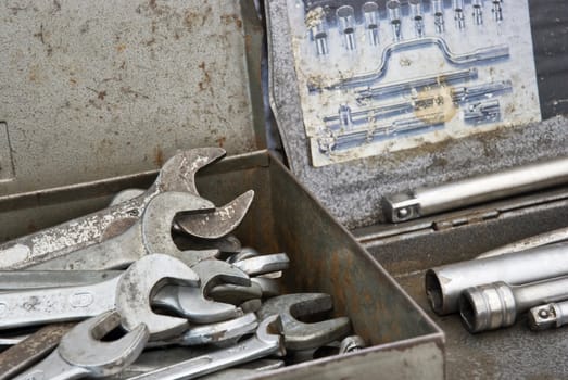 Detail shot of a box full of spanners of differente sizes.