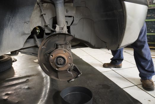 Detail shot of a car without wheels lifted by a repair shop lift