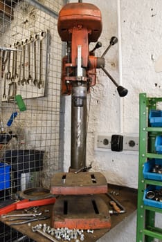 Front shot of a repair shop drilling machine, with huge drillbit attached.