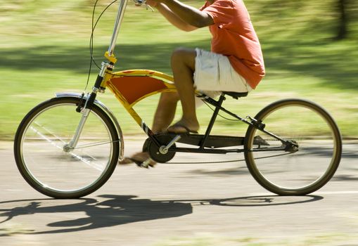 Panning side-shot of a boy riding a customized bicycle.