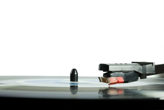 Record player needle close-up, with LP underneath.l