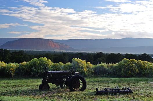 an old tractor set against mountains of new mexico in the USA