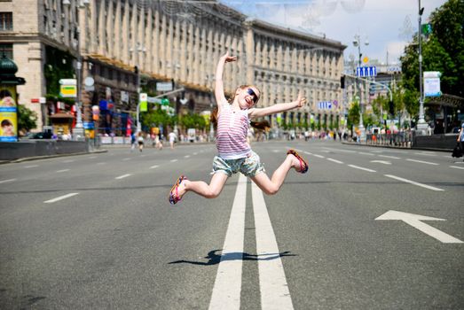 Little girl jumping in the middle of the street