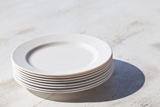 Stack of plates and shadow, on dining table