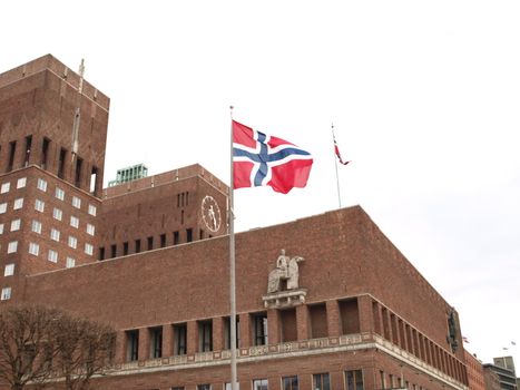 In the picture you can see the town hall of Oslo. In front you can see a Norwegian flag flutters in the wind.