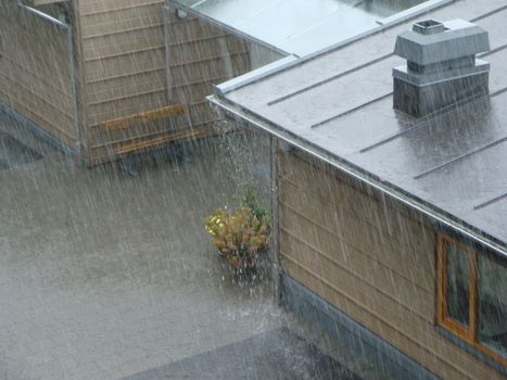 The rain is pouring down and the gutter is overflowing