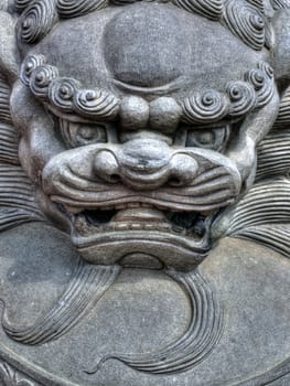 Asian lion head sculpture protecting the entrance to a temple.