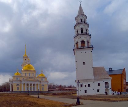 Demidov's inclined tower on a background of the Spaso-Preobrazhenskiy temple. The city of Nevjansk. Sverdlovsk area. Russia.